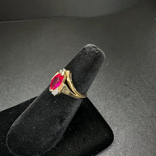 10k yellow gold ring w ruby stone in center & diamonds